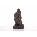 A Chinese carved Zitan wood figure of Hotei accompanied by Jin Chan toads on a rocky base. 22 cm