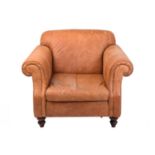 An Edwardian-style distressed tan hide oversized club armchair, twentieth century, with roll-over