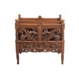 A Victorian carved oak Canterbury, the two divisions with profusely carved foliate scroll sides,