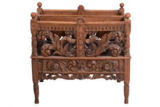 A Victorian carved oak Canterbury, the two divisions with profusely carved foliate scroll sides,