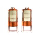 A pair of Edwardian marquetry inlaid mahogany serpentine display pier cabinets, in the manner of