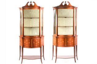 A pair of Edwardian marquetry inlaid mahogany serpentine display pier cabinets, in the manner of
