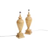 A pair of large carved wood and gilt gesso table lamps of inverted baluster form on square plinth