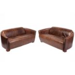 A pair of art deco style distressed brown hide two-seat sofas with swept arms and block feet. 167 cm