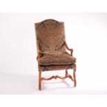 A French Loius XIV walnut fauteuil with arched back swept arms over a moulded vitruvian scroll