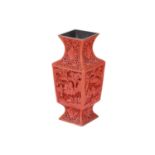 A Chinese cinnabar lacquer square section baluster vase, 20th century, carved with typical scenes of