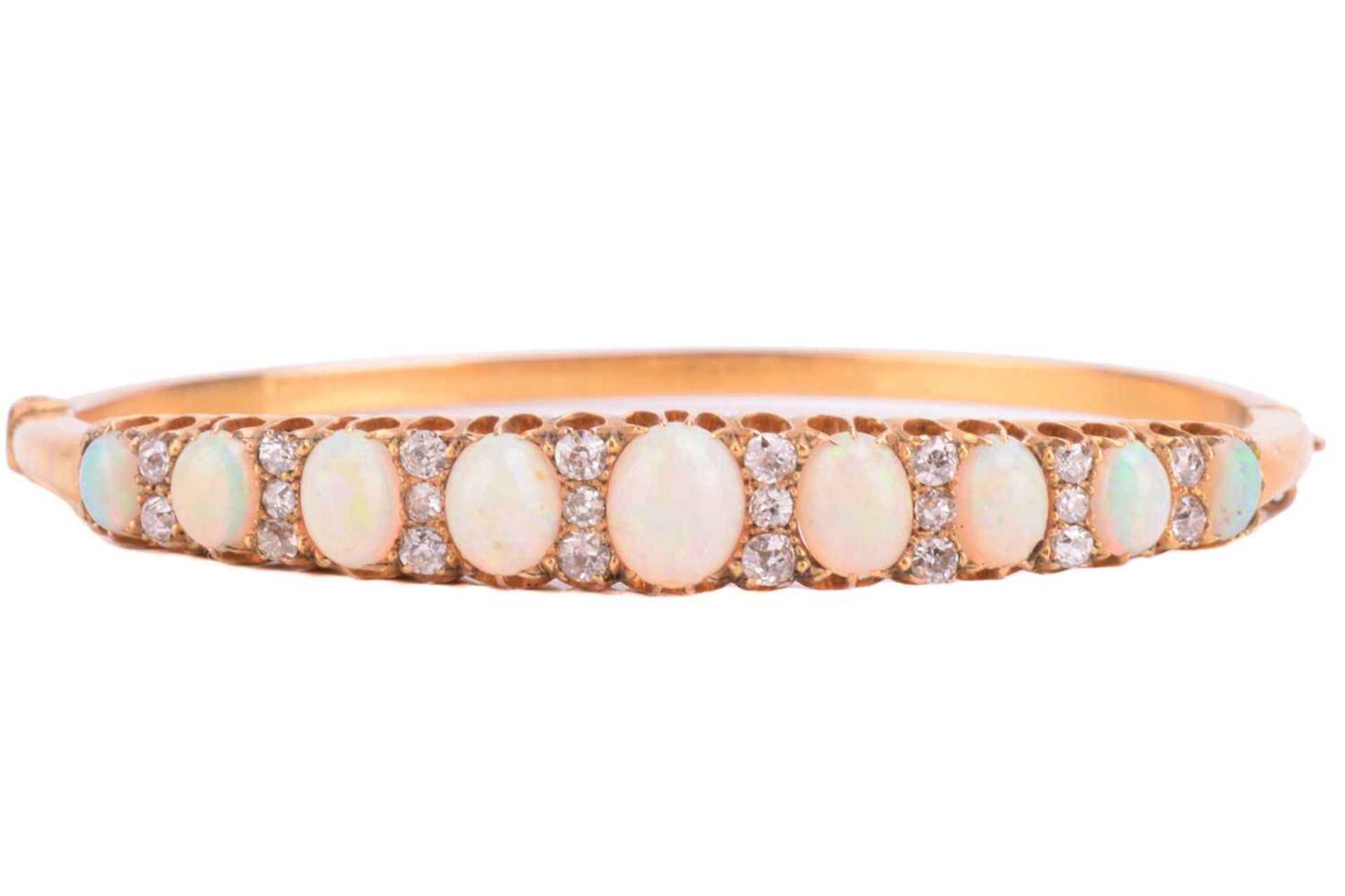 A Victorian opal and diamond hinged bangle, the bracelet features a graduated row of nine oval