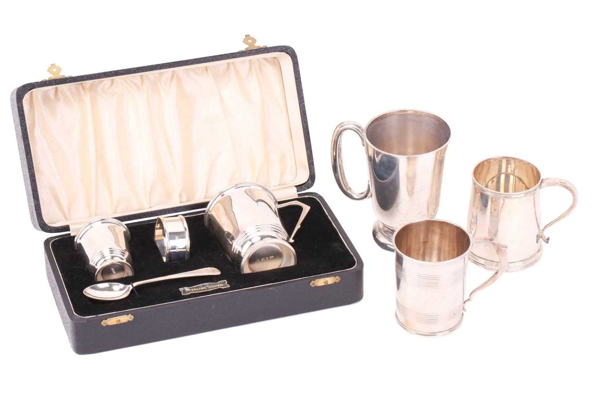 A cased silver christening set comprising a Christening mug, egg cup and spoon, napkin ring,