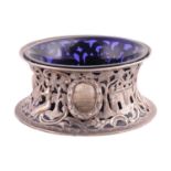 An Irish silver dish ring with blue glass liner; the sides pierced and engraved with bucolic scenes,