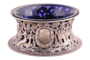An Irish silver dish ring with blue glass liner; the sides pierced and engraved with bucolic scenes,