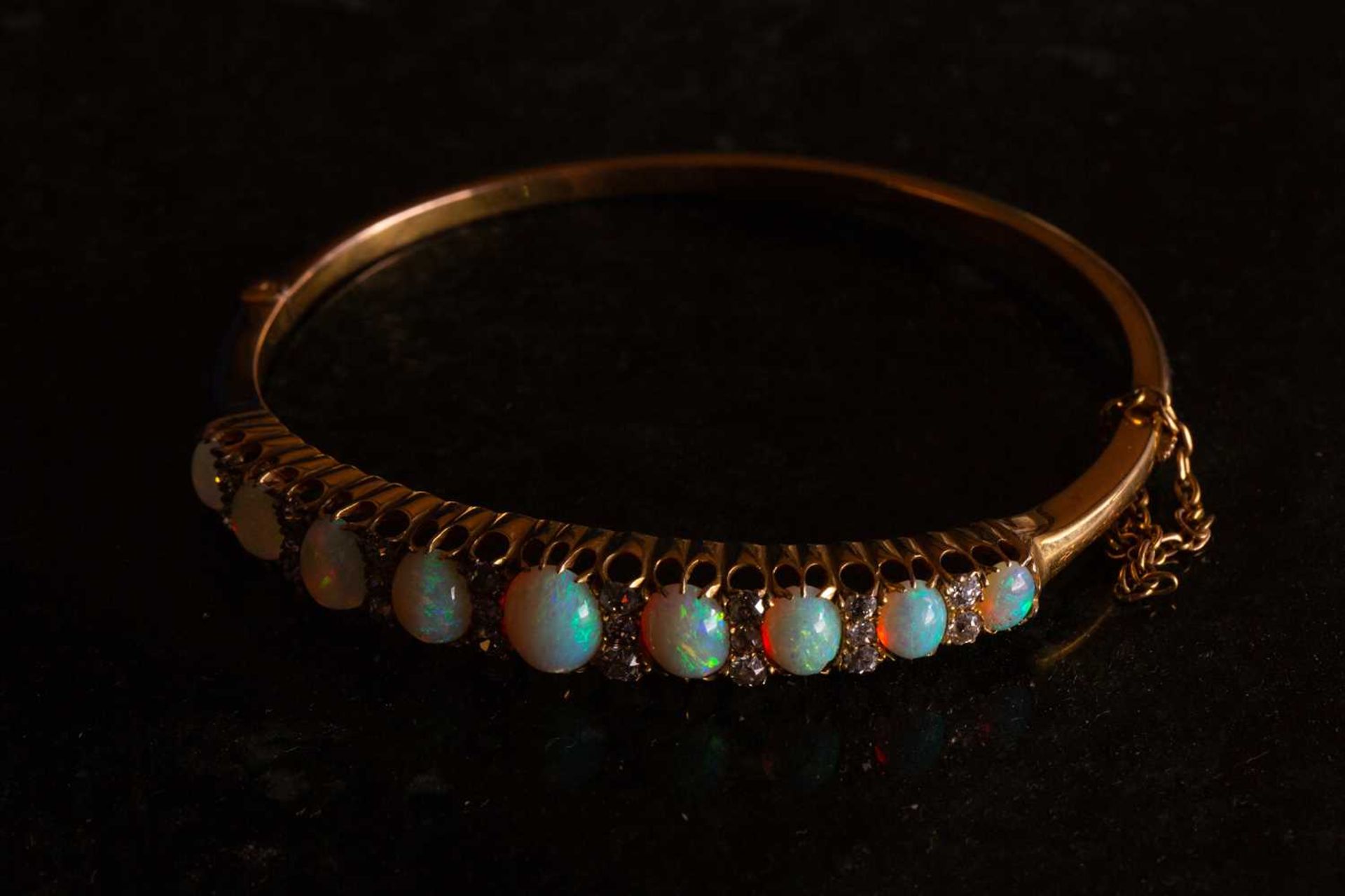 A Victorian opal and diamond hinged bangle, the bracelet features a graduated row of nine oval - Image 5 of 5