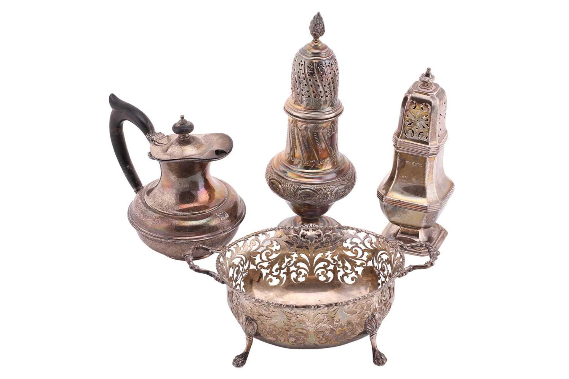 A small collection of silver comprising two silver sugar casters, a pierced basket with two