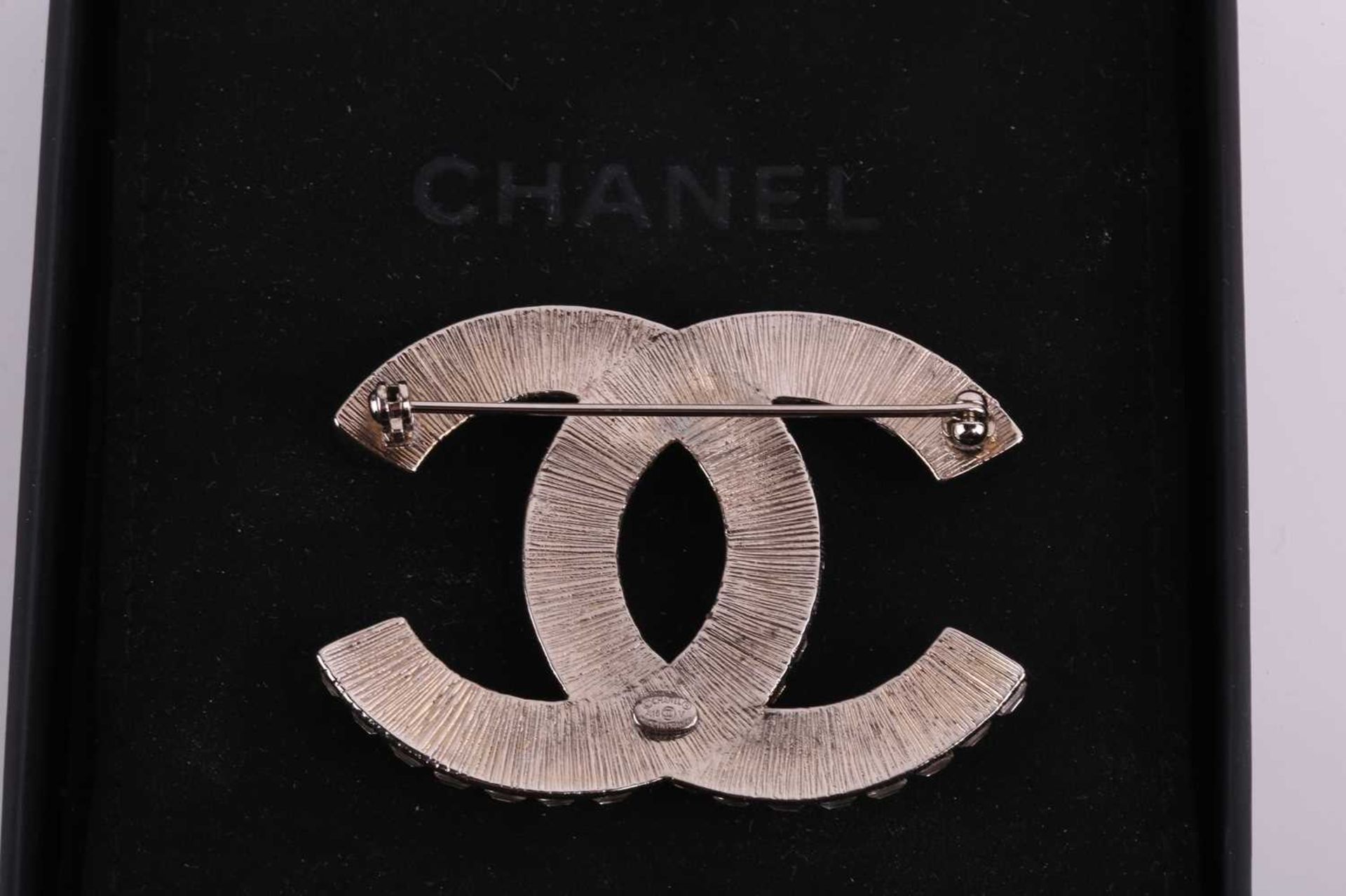 Chanel - an interlocking CC logo brooch encrusted with baguette rhinestones, signed A18V, 5.2 cm - Image 5 of 5