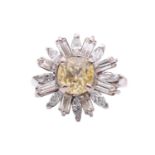 A yellow sapphire and diamond daisy cluster ring, set to the centre with a cushion shape yellow
