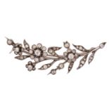 A daisy spray brooch set with old-cut diamonds, comprising realistically formed flowerheads and