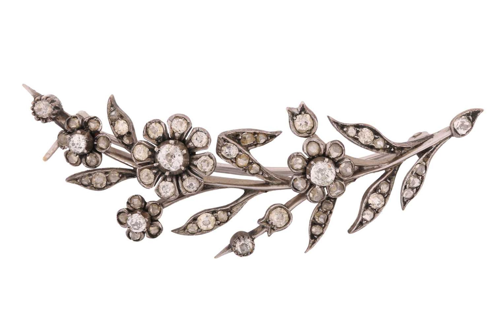 A daisy spray brooch set with old-cut diamonds, comprising realistically formed flowerheads and