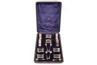 A silver ten-piece condiment set in fitted case, comprising of four oval salts with blue glass