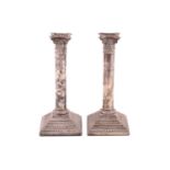 A pair of column candlesticks, with Corinthian capitals on stepped square weighted bases, Birmingham
