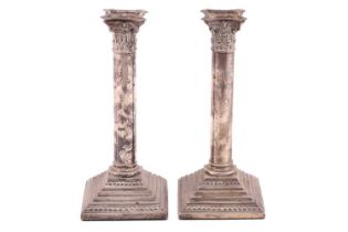 A pair of column candlesticks, with Corinthian capitals on stepped square weighted bases, Birmingham