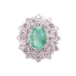 An emerald and diamond cluster ring, the fracture-filled emerald centrally set within a cluster of