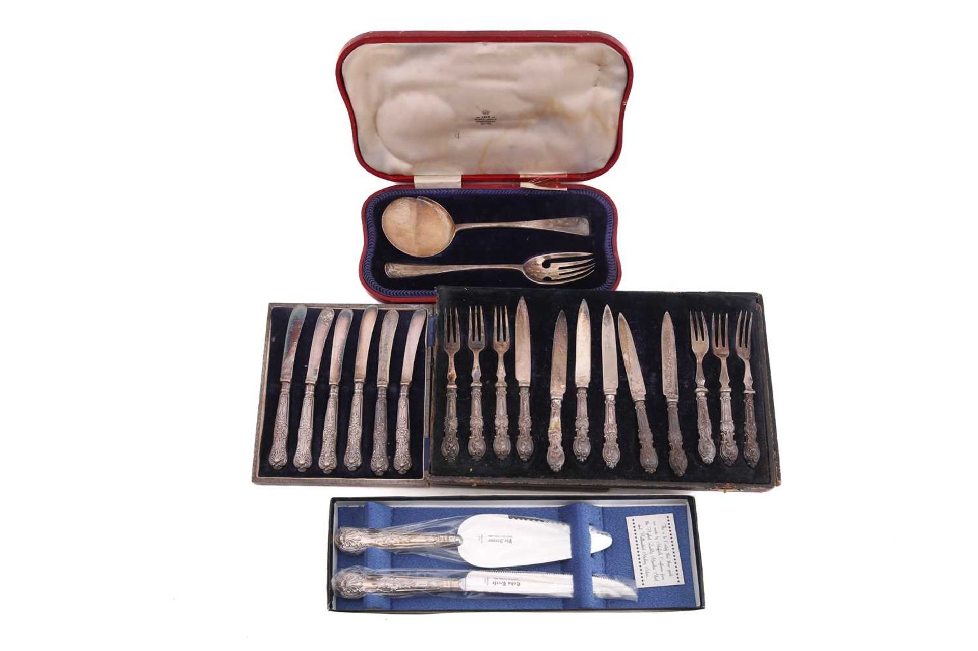 Four cased sets of silver flatware comprising a serving fork and slice in red leather case, a set of