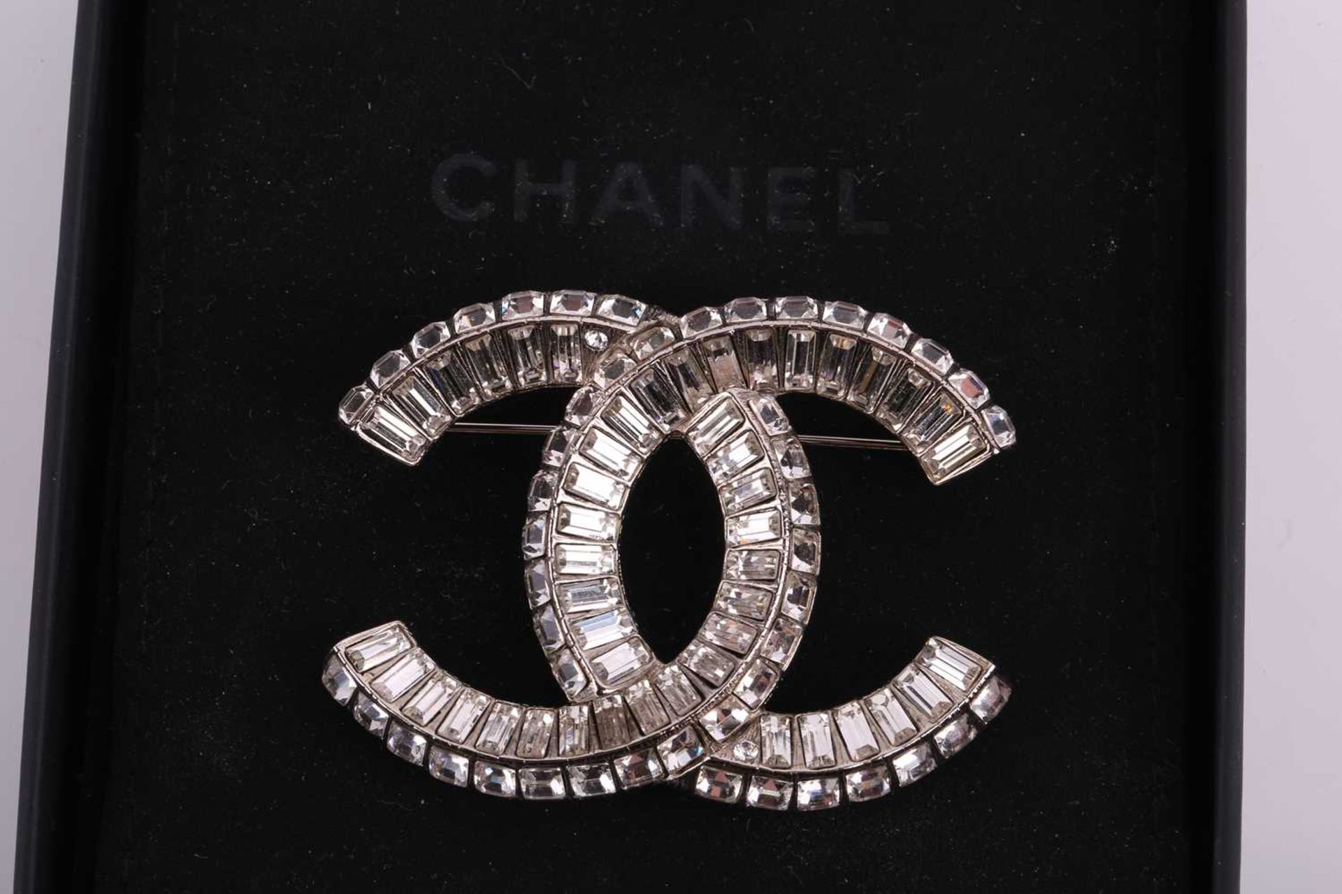 Chanel - an interlocking CC logo brooch encrusted with baguette rhinestones, signed A18V, 5.2 cm - Image 4 of 5