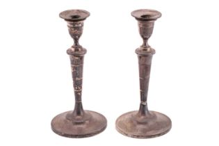 A pair of late George III silver candlesticks, of round form with flared round weighted bases,