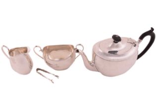 A three-piece silver tea set; rounded rectangular with reeded borders and scroll handles. The teapot