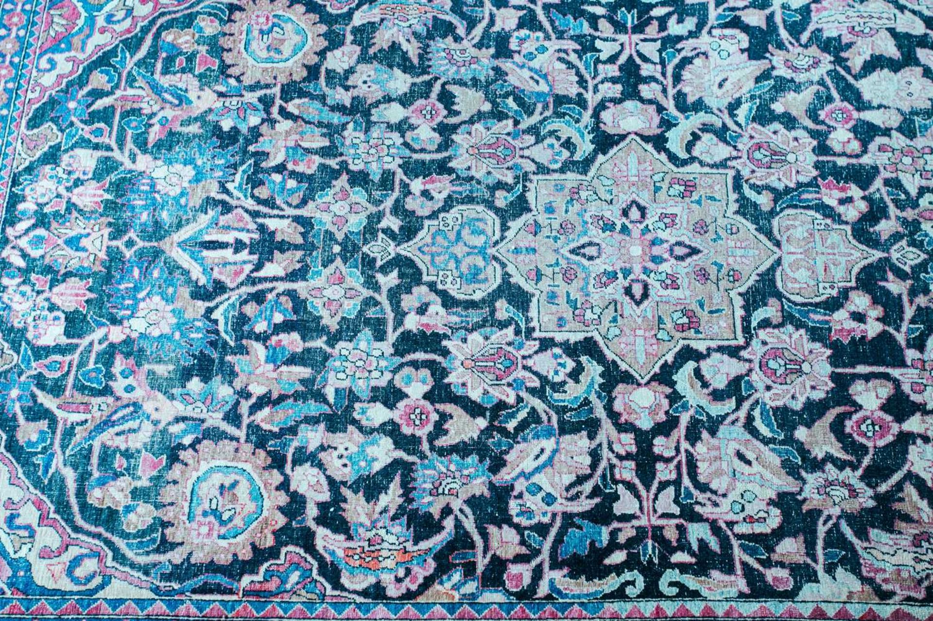 An antique black/blue ground Kerman carpet, with a central star and corners with multiple vines - Image 2 of 3