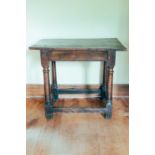 An 18th century oak side table, on turned supports, 71 cm high x 83 cm wide x 52 cm deep.