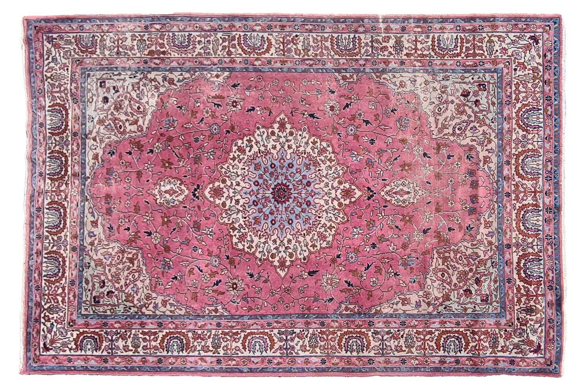 An old pastel pink ground possibly Turkish carpet with a central boss with hanging lanterns within