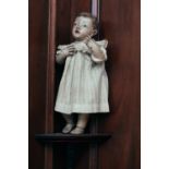 An 18th-century Spanish carved and polychromed wood figure of a cherub, with inset glass eyes, and