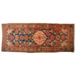 An antique large Mahal runner with dark blue ground a trellis of large flower heads and a central