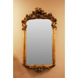 An 18th-century French giltwood wall mirror, 97 x 49 cm, the plate 67 cm x 36.5 cm, (re-gilt and