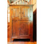A 19th-century French oak two-door cupboard, the moulded cornice above a panelled door over a