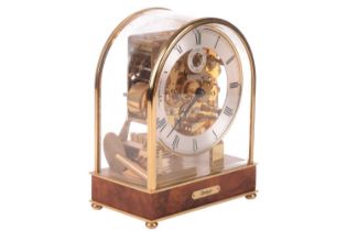 A Kieninger 8-day contemporary mantel clock, with brass arched and glazed case, with skeletal dial