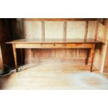 A 19th century French fruitwood kitchen table, with frieze drawer and square section tapering