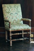 An 18th-century upholstered open armchair, on turned stretchered supports, 106 cm x 62 cm, the