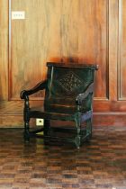 A 17th-century oak wainscot chair, with lozenge carved panel back, of low and wide proportions, 75