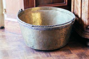 A large brass circular preserve pan, with wrought iron swing handle, 60cm diameter. Provenance: