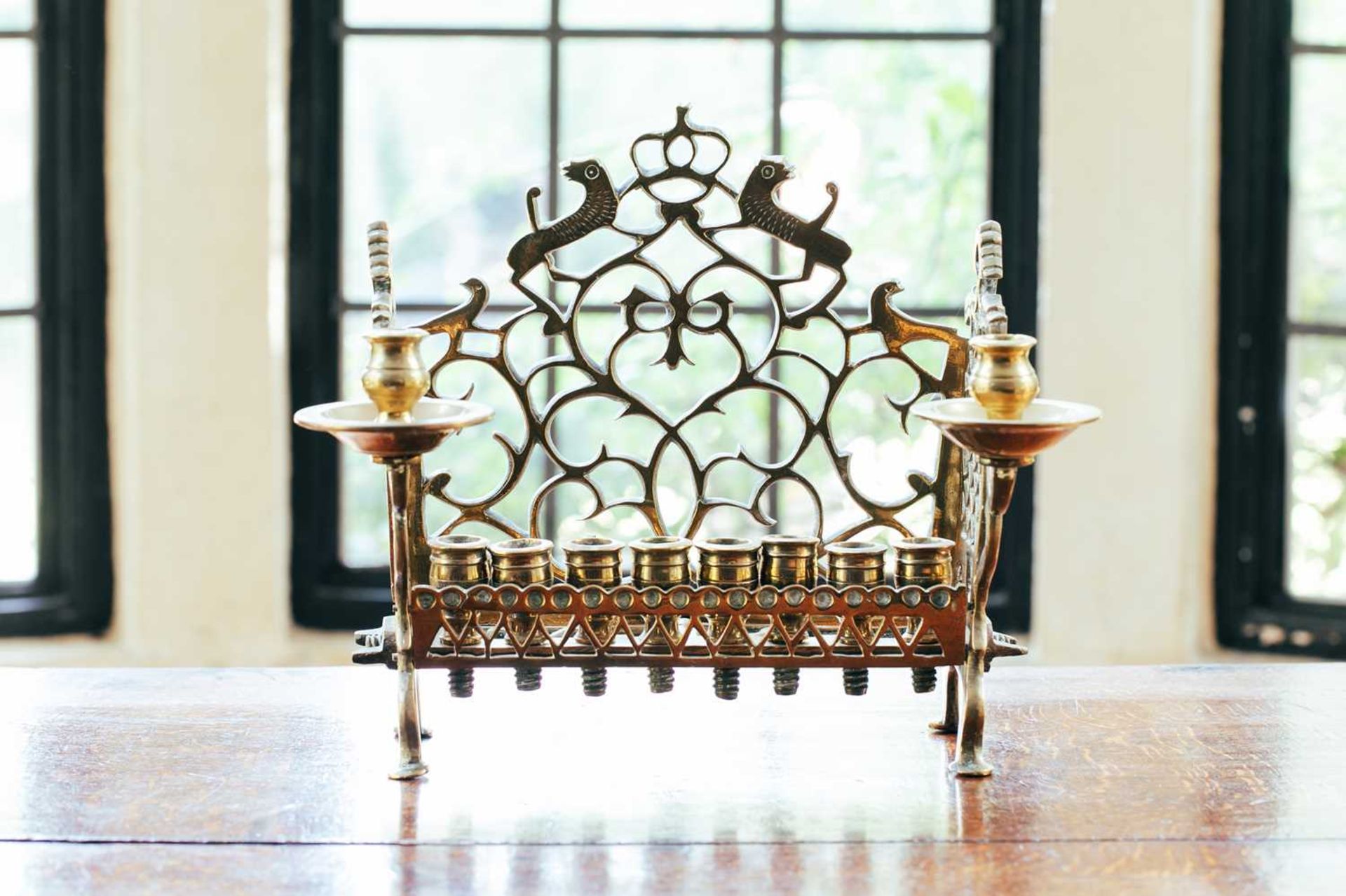 An 18th century Dutch/German brass menorah, with row of eight sconces and side lights, fretwork