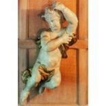An 18th century Northern European painted softwood cherub, with curly hair swathed in a billowing