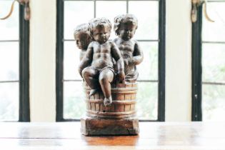 A 19th-century Continental carved figural group, three putti in a coopered barrel, 36 cm high x 21
