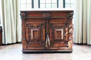 A late 17th-century oak cabinet, the pair of doors with bolection moulded panels, frieze drawer