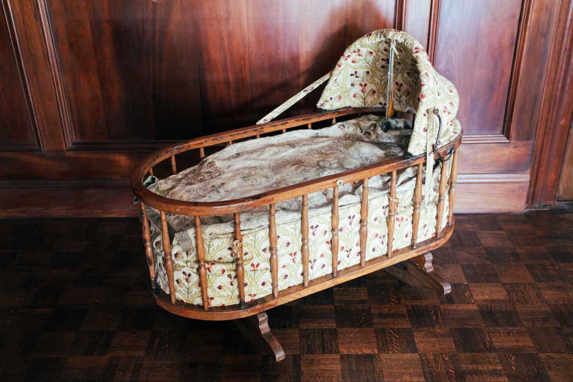 An oak spindle frame child's cot, 19th century, with fitted drapery, 108 cm long x 49 cm wide x 80