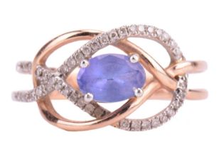 A tanzanite and diamond dress ring in a knot design, centred with an oval-cut tanzanite of pale