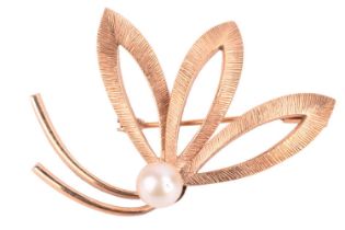 A faux pearl brooch of stylised floral form, comprising a round imitation pearl of 7.0 mm set to a