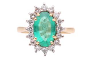 An emerald and diamond cluster ring, the oval mixed cut emerald measuring 11.4 x 7.3 x 3.7mm, within