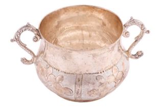 A Charles II silver two-handled porringer, the body decorated with four panels of flowerheads,