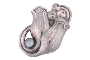 Georg Jensen - a tulip brooch set with moonstone, repoussé and chased in a stylised tulip spray